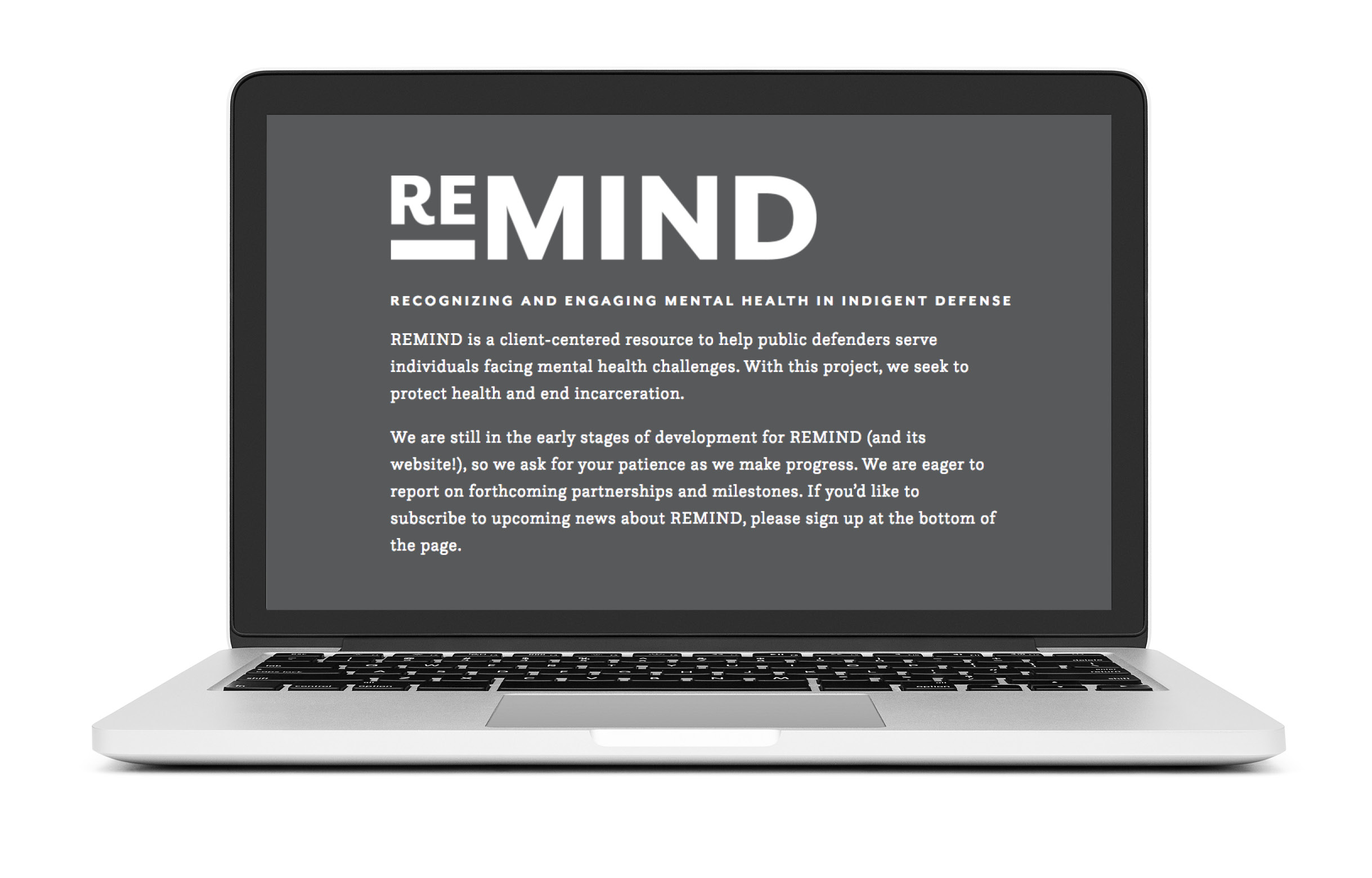 A Mac laptop with the ReMIND landing page on it. The landing page is gray with white text explaining the project. 
